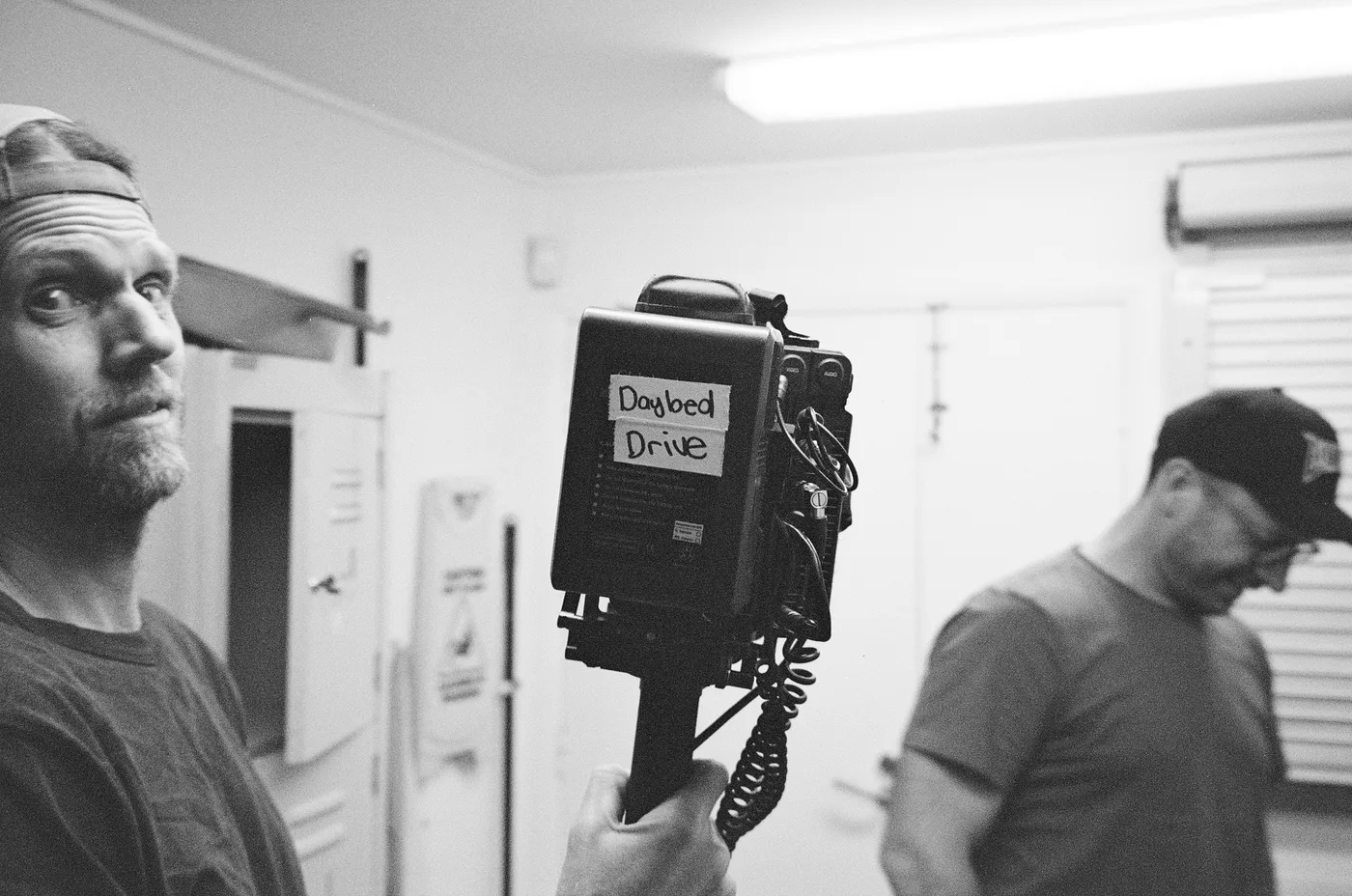 Mark Tipple holding up a camera with a Daybed Drive label taped to it